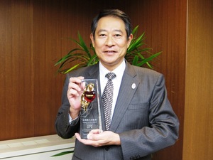 台湾観光貢献賞の盾を持つ区長の写真