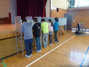 模擬投票を行う小学生の写真