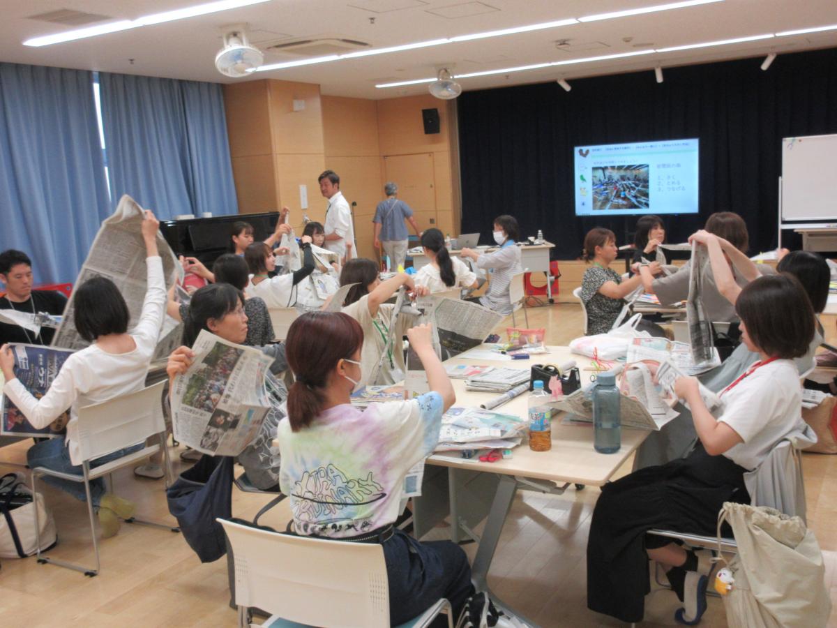 新聞紙を破いて、作品をつくっている風景