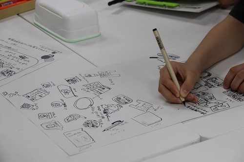 紙に鉛筆でイラストを描く様子