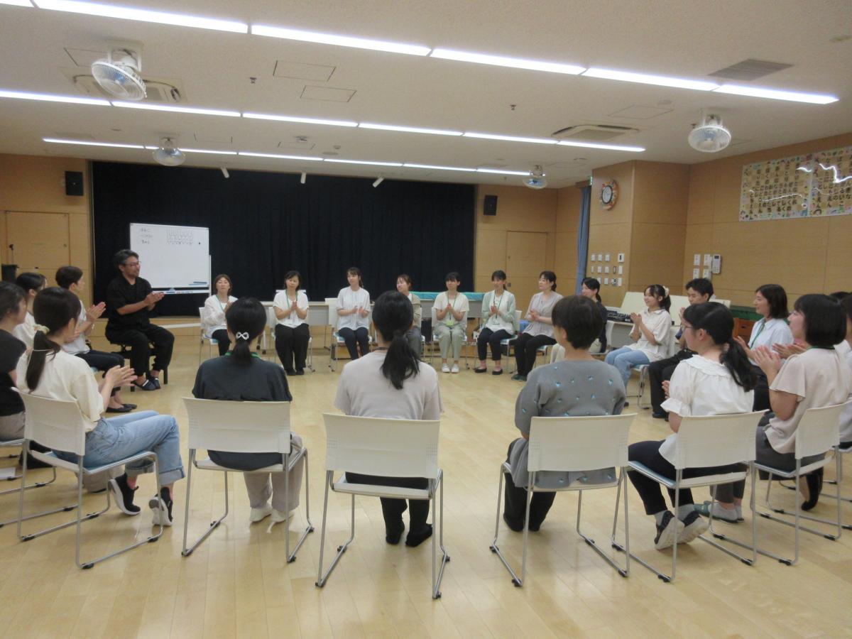 参加者が輪になって手拍子をしている様子